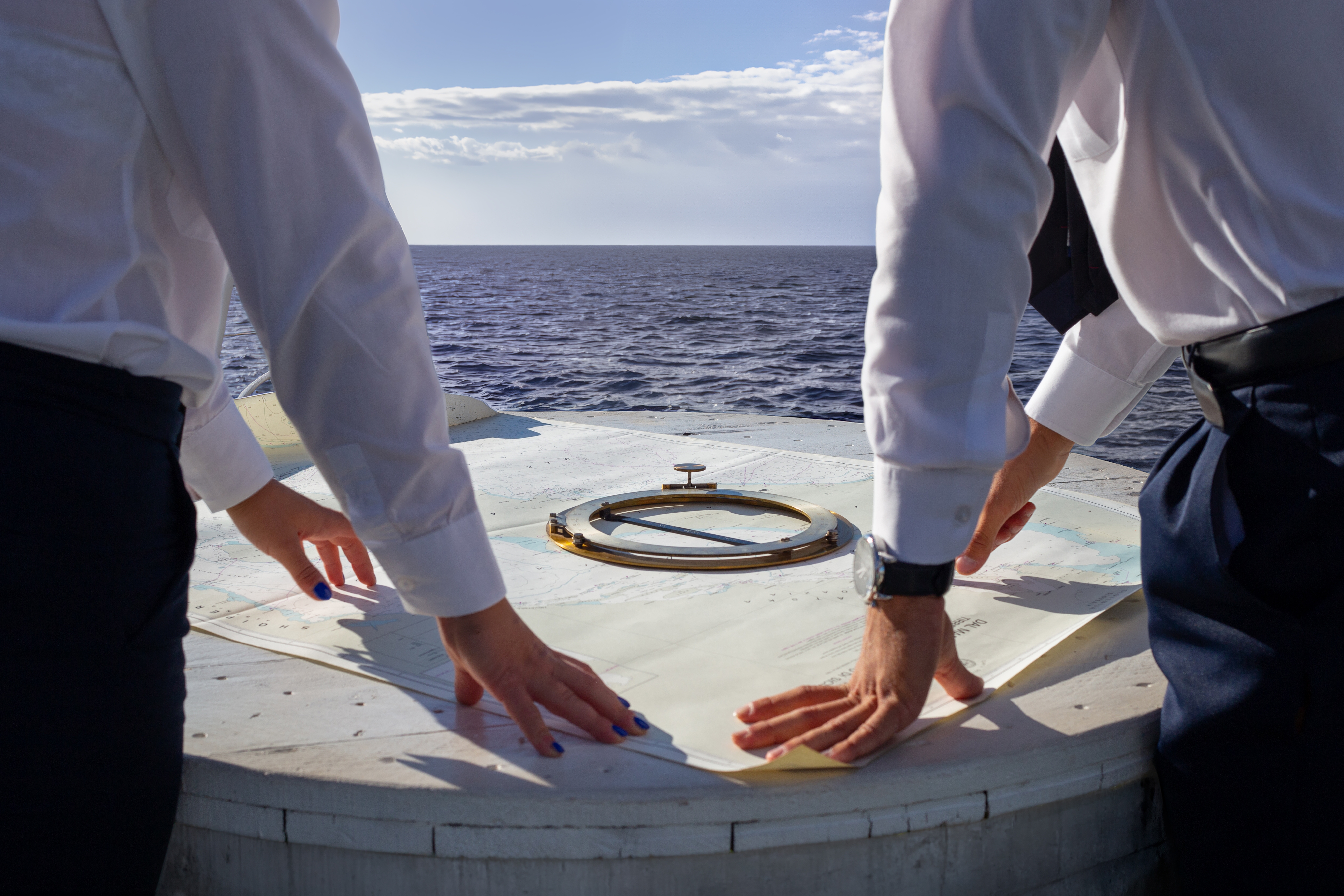 two men navigating on a boat looking at the map